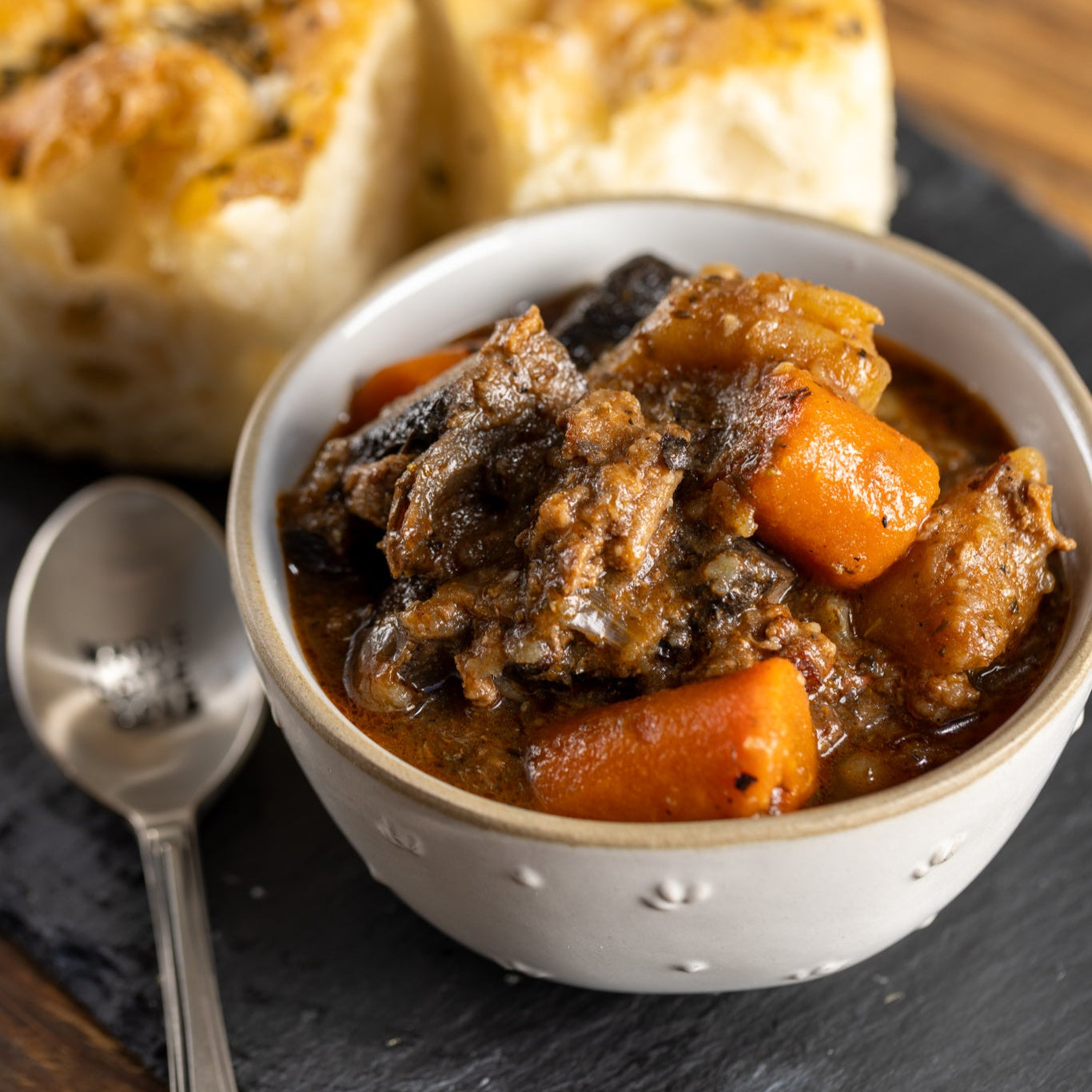 Frozen beef stew with sirloin steak, potato, carrot, and mushroom, reheated and served with bread