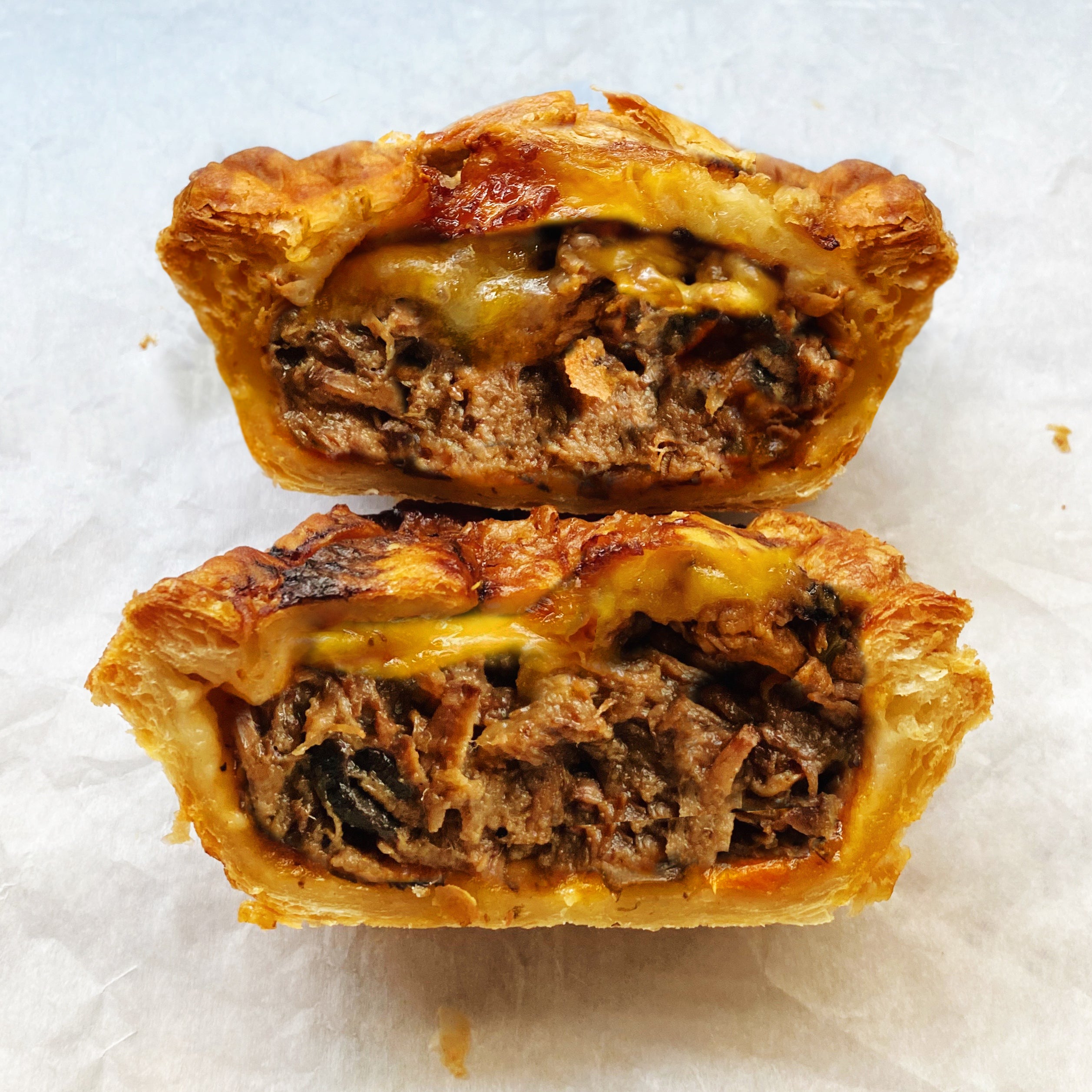 Cross section of a steak and cheese pie on parchment paper