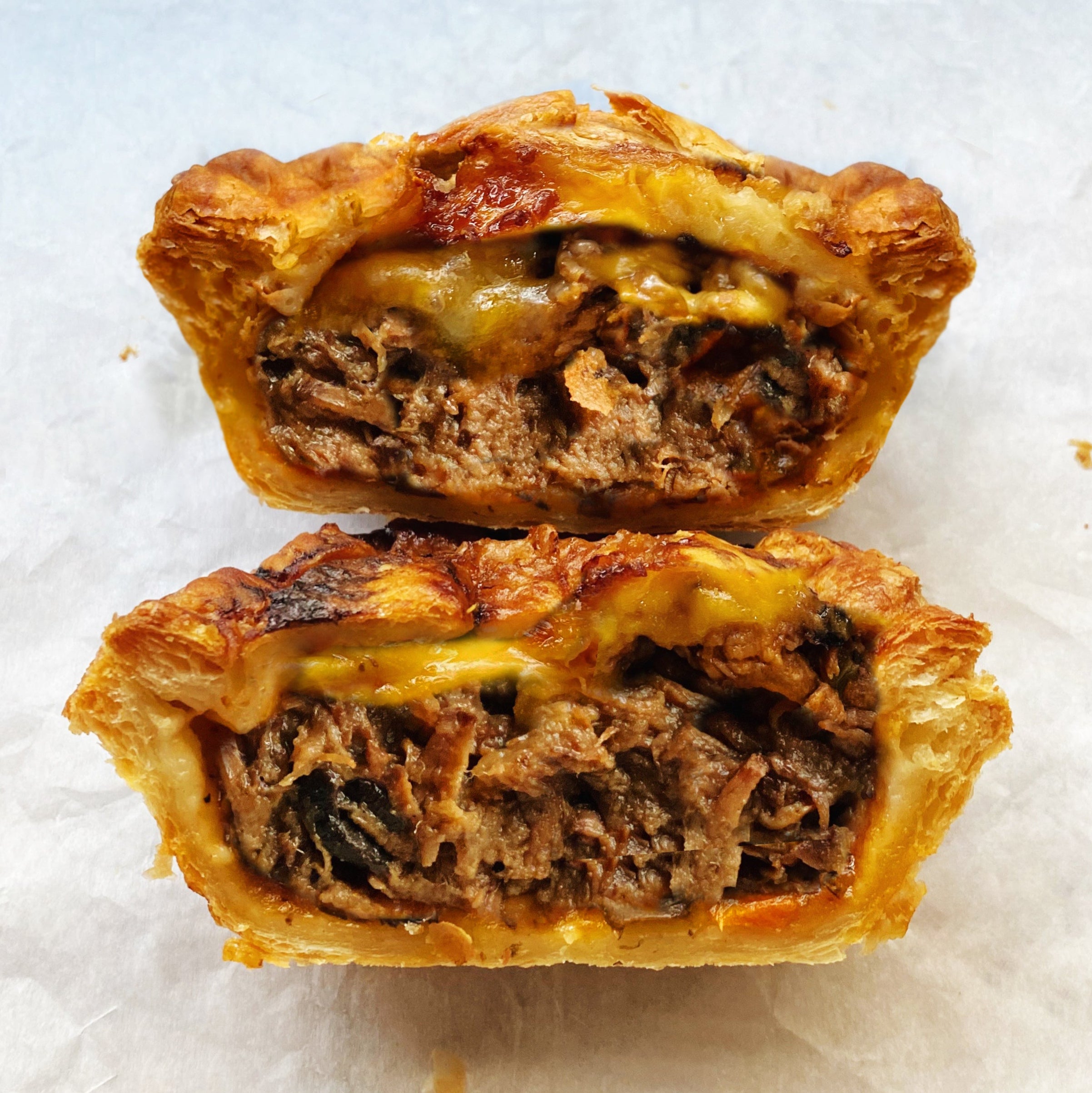 Bake-at-home beef pot pie filled with tender sirloin steak and sharp cheddar cheese in a golden puff pastry crust