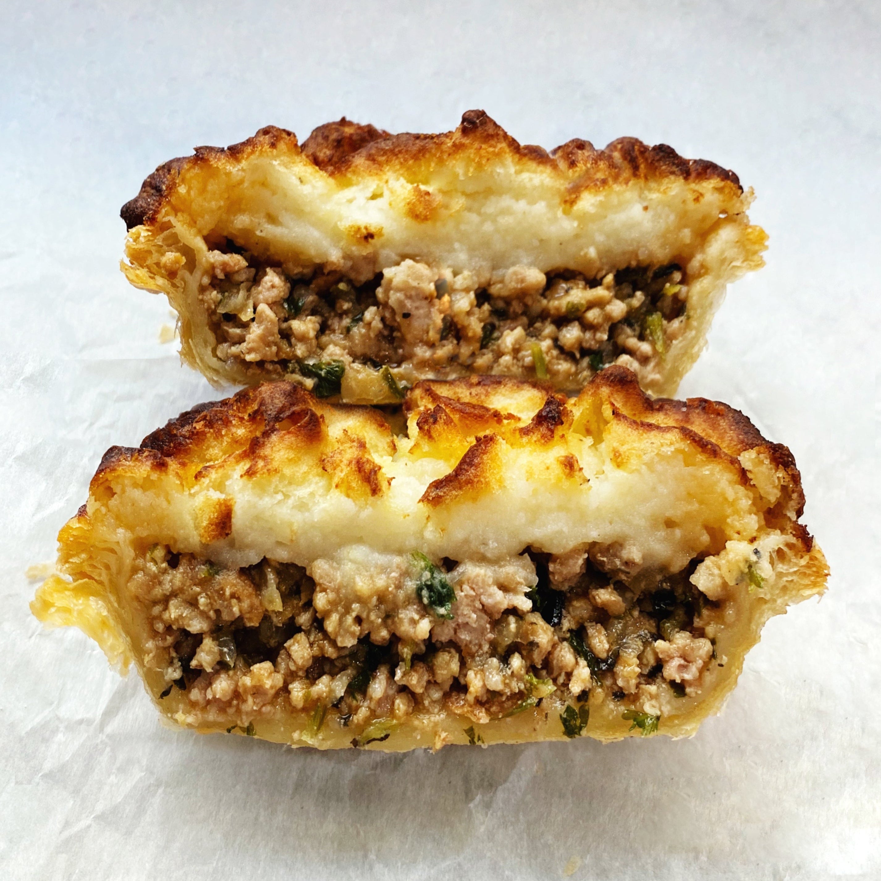 Savory pork shepherd’s pie topped with mashed potatoes, ready to bake at home